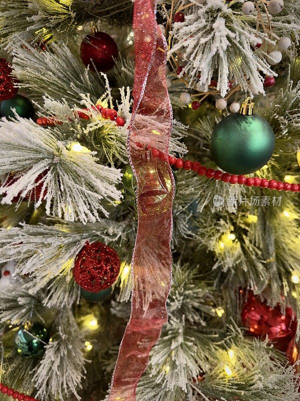 Red and green ￼ribbon and ornaments on branches